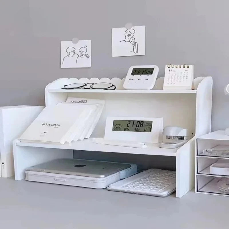 A white two-layer desktop organizer shelf featuring a laptop, keyboard, and various stationery items.
