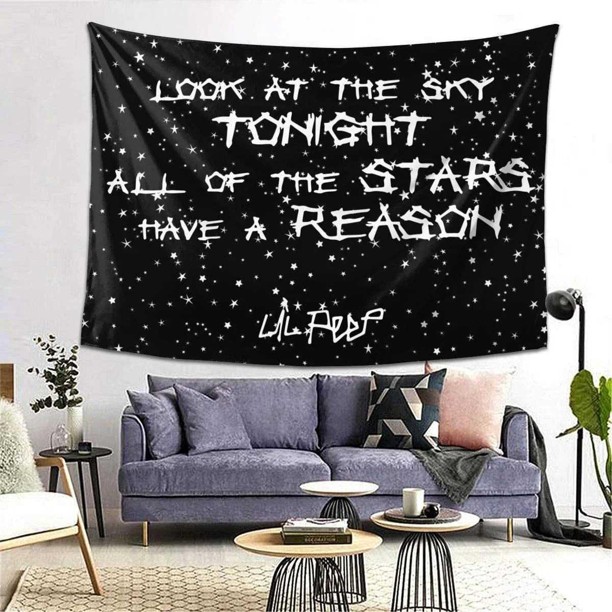 A dark tapestry wall hanging featuring stars and the text Look at the sky tonight all of the stars have a reason.