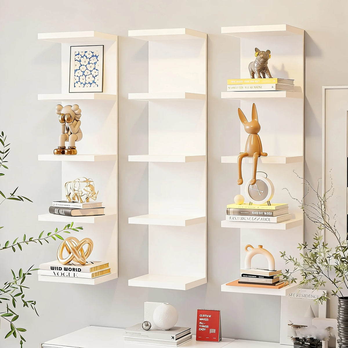 A white five-tier wall-mounted storage shelf displaying various decorative items and books.