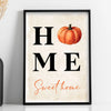 Framed canvas wall art featuring the text HOME and Sweet home with an orange pumpkin illustration on a light background