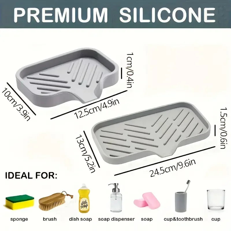 A set of gray silicone kitchen tools including a faucet splash guard, drying mat, sponge, brush, dish soap, and cup/toothbrus