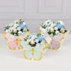 A set of floral butterfly decorations featuring pastel pink and mint green butterflies on a gold background for a garden part