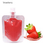 A clear bottle of strawberry lip oil gloss next to fresh strawberries.