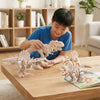 A boy is assembling or examining a set of 3D printed dinosaur skeleton figurines, including a T-Rex and Mosasaurus.