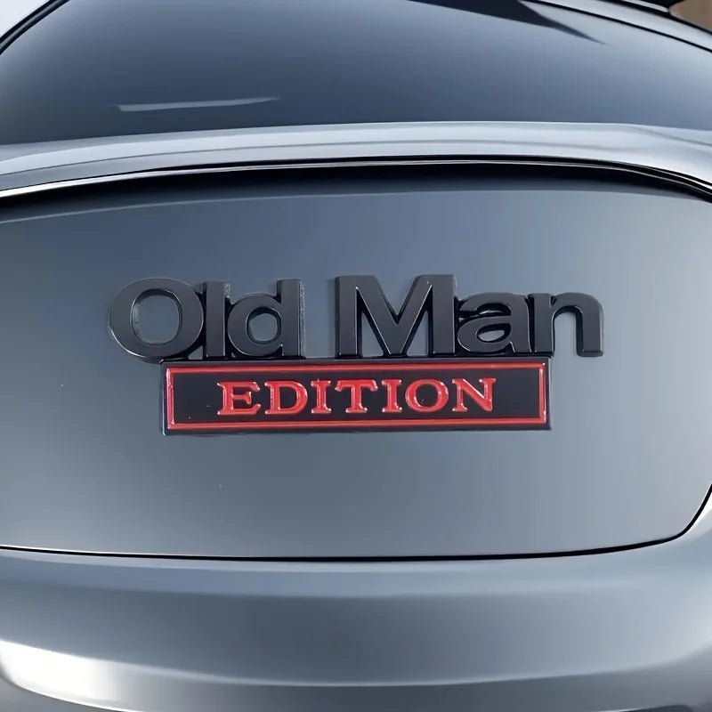 A close-up of a silver car door featuring an Old Man Edition emblem on the side.