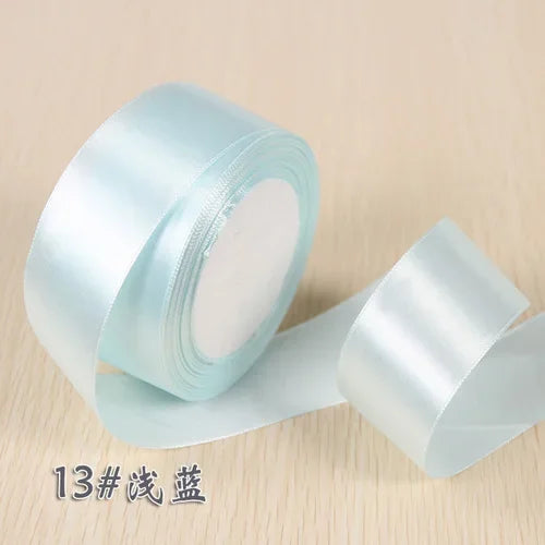 A roll of light blue silk satin ribbon used for gift wrapping and craft projects.