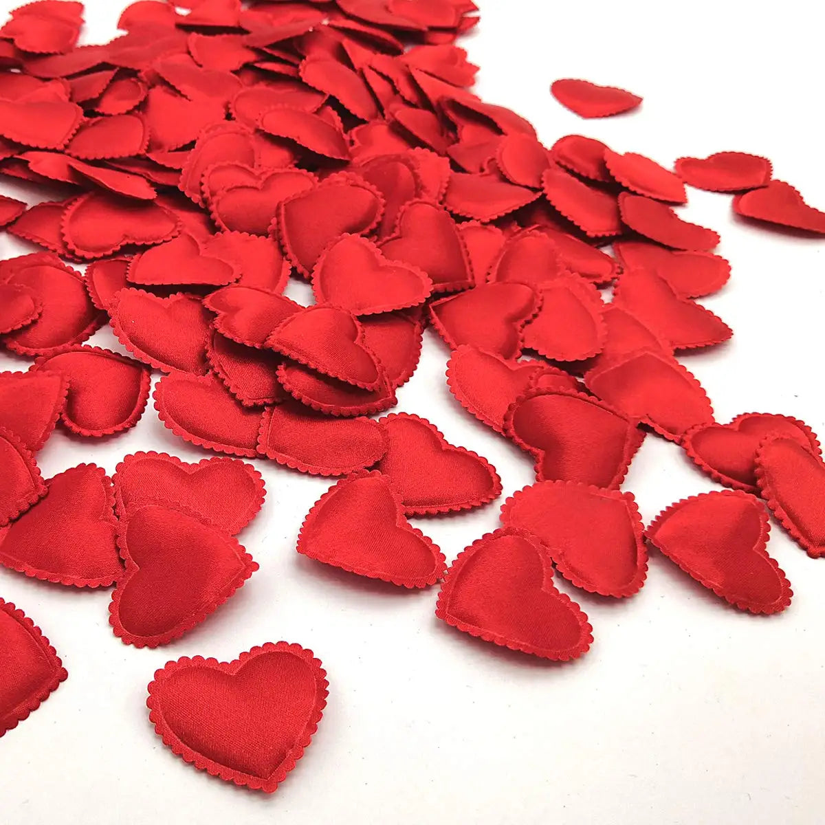 A pile of red fabric heart throwing petals for weddings and parties.
