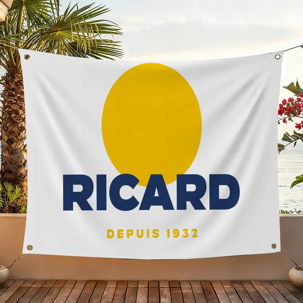 A white flag featuring a large yellow circle and the text RICARD DEPUIS 1932, displayed outdoors.