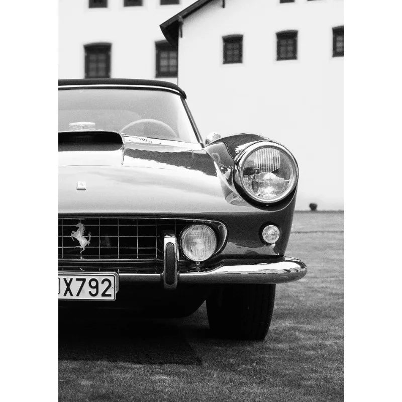 Schwarz-weißes Foto eines klassischen Autos mit offenem Motorhaube vor einem weißen Gebäude.