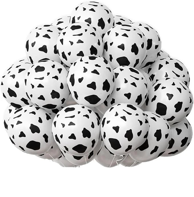A bunch of white latex balloons with a black cow print pattern for party decor