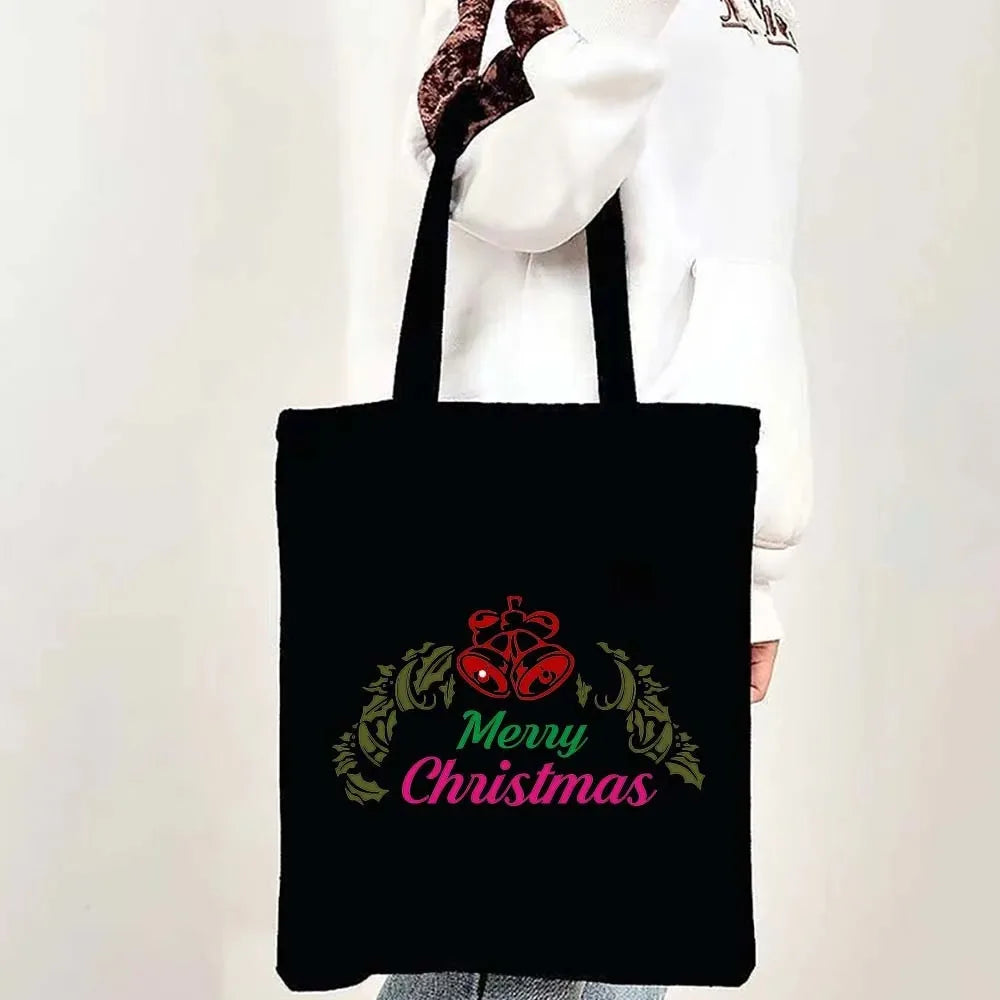 Black tote bag featuring a festive Christmas design with a wreath and the text Merry Christmas.