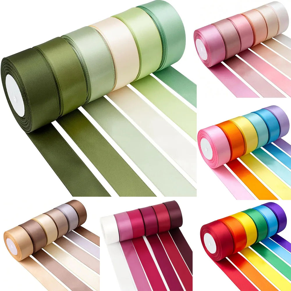 A collection of satin silk ribbons in various shades of green, pink, orange, and yellow rolled for crafting.