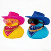 A yellow rubber duck wearing a pink cowboy hat and gold chain, next to a blue rubber duck wearing a blue hat and sunglasses.