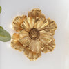 A large, golden, flower-shaped resin wall art piece with layered petals.
