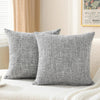 A set of two solid gray linen pillows resting on a white textured surface.