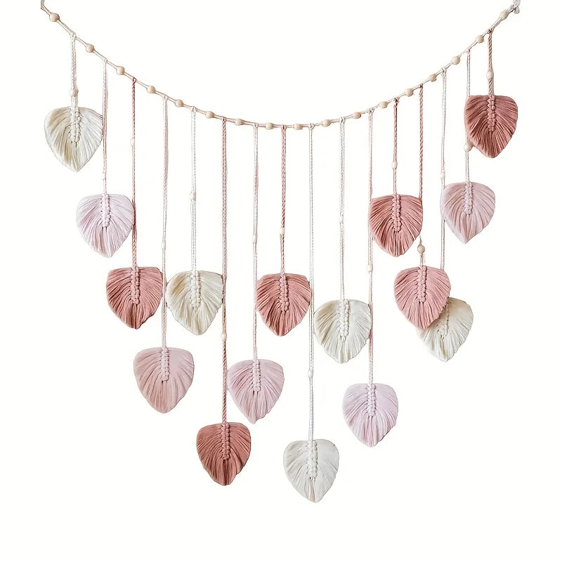 Handwoven pink leaf tassels hanging from a string, used as a wall decoration.