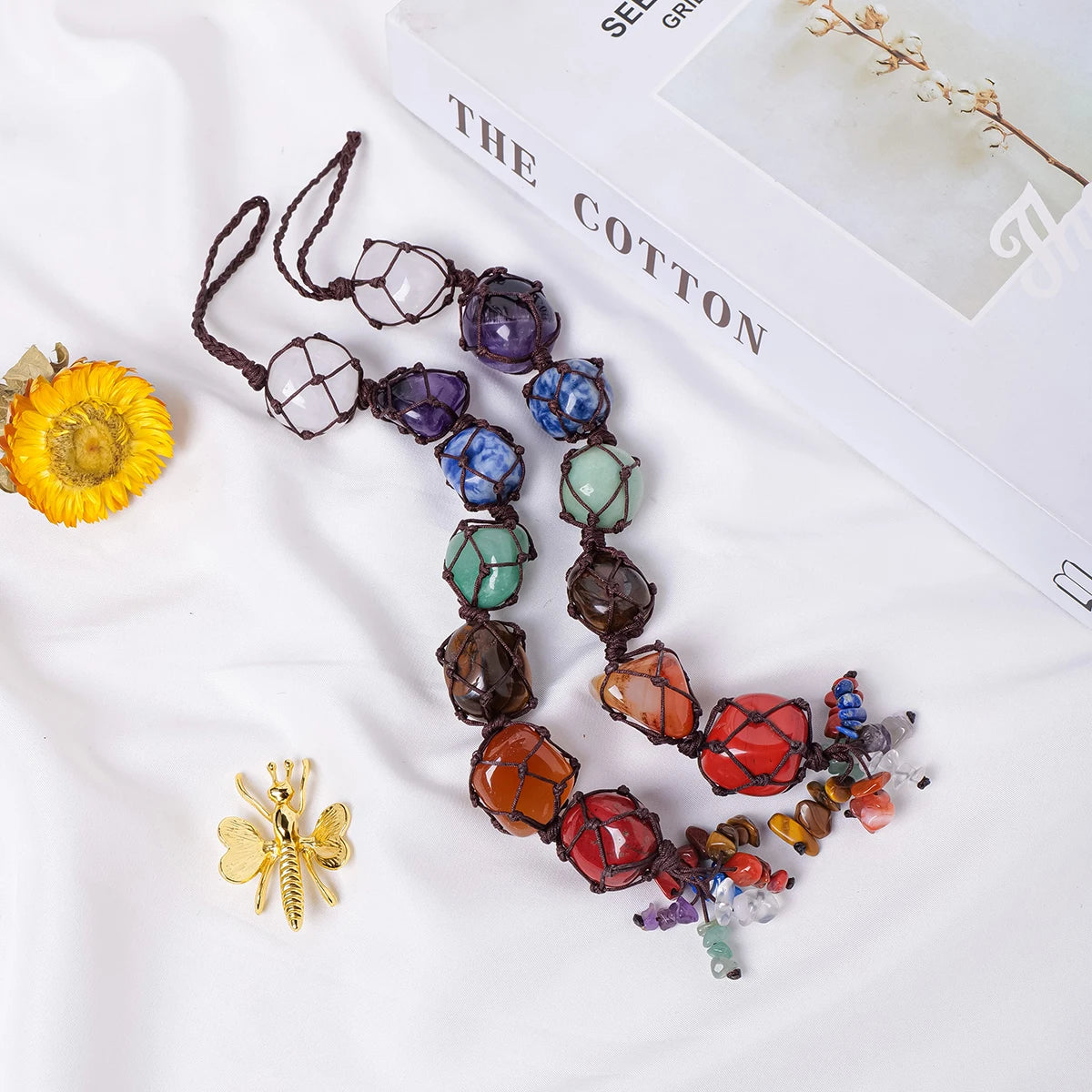 A necklace featuring various colored crystal stones strung together on a leather cord.