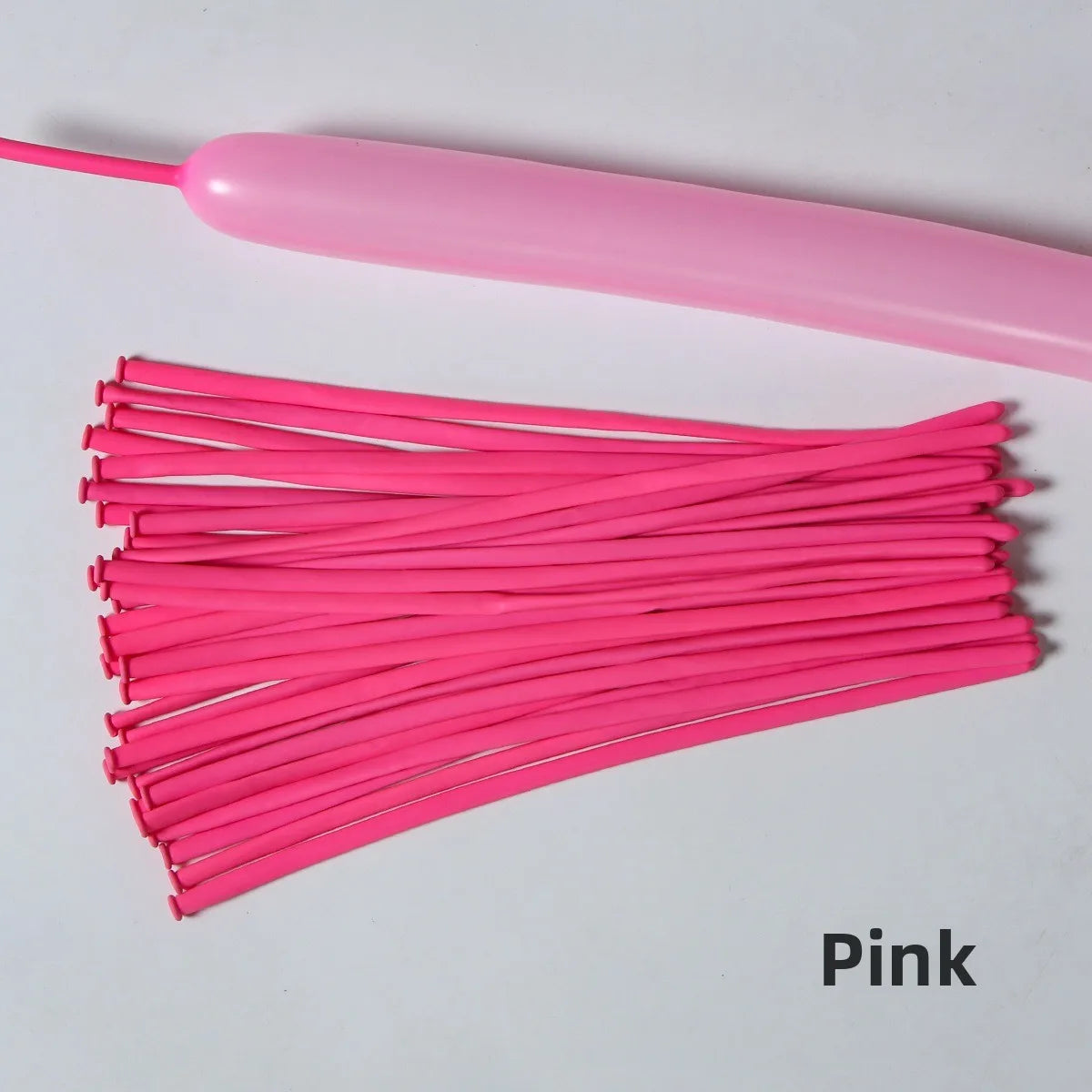Pink latex strip balloons laid out on a white surface.