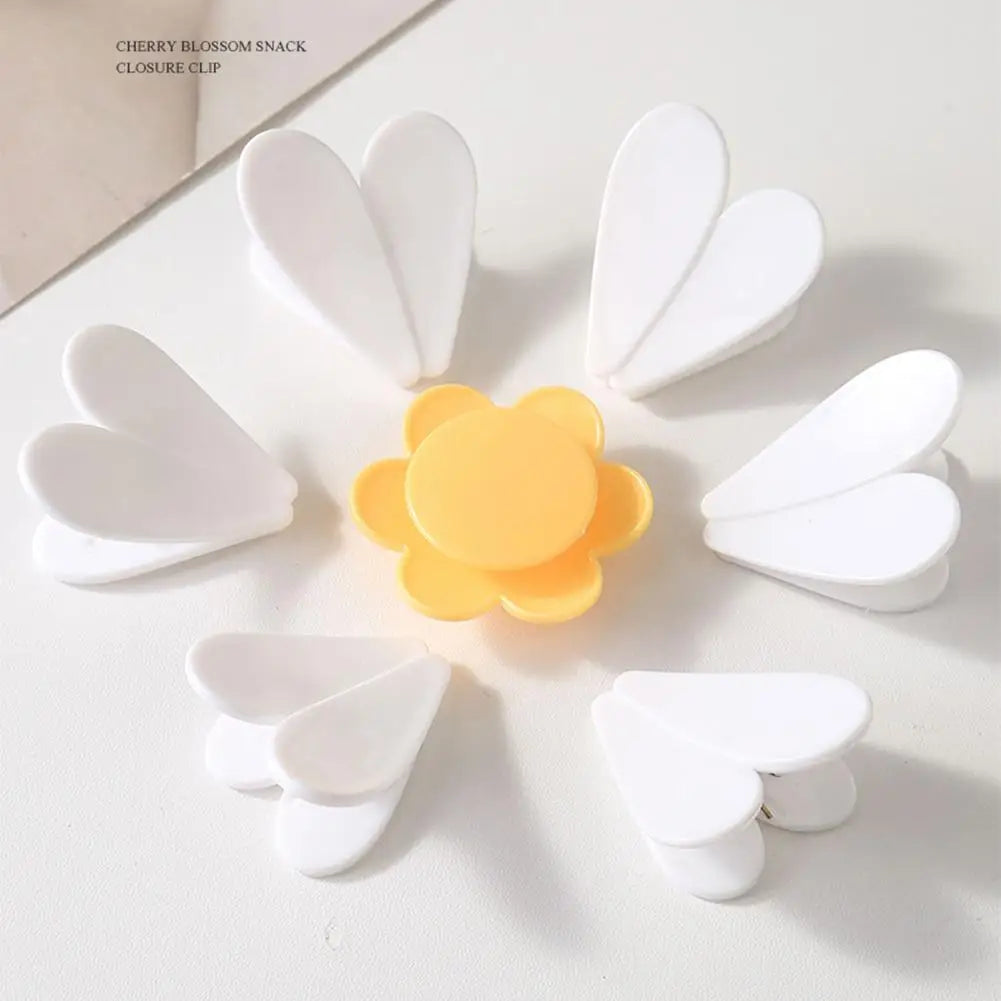 Pince de fermeture magnétique blanches en forme de fleurs sur fond blanc.