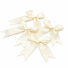 A set of cream-colored satin ribbon bows tied in decorative knots.