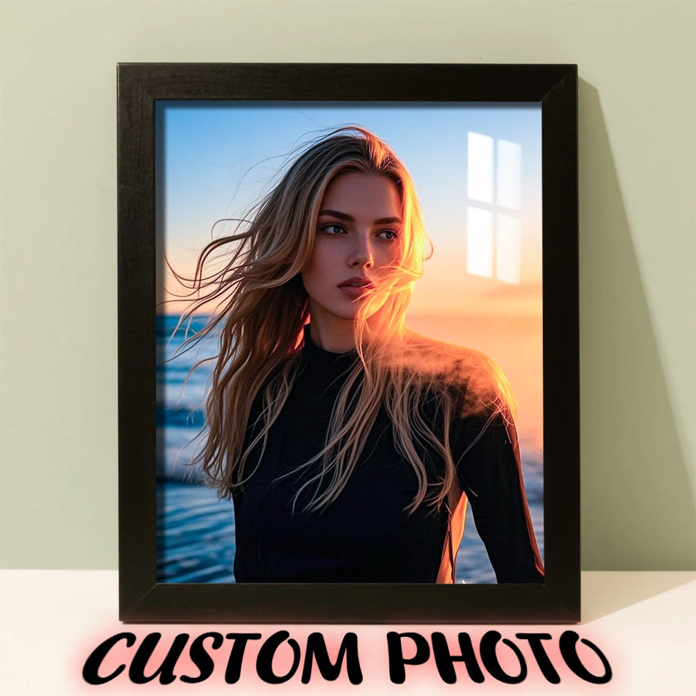 A framed photo of a woman with long blonde hair looking towards the sunset, set against a blue ocean background.