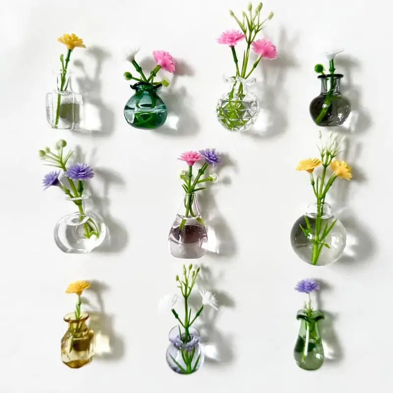 A collection of magnetic glass flower vases in various shades of green and pink displayed against a white background.