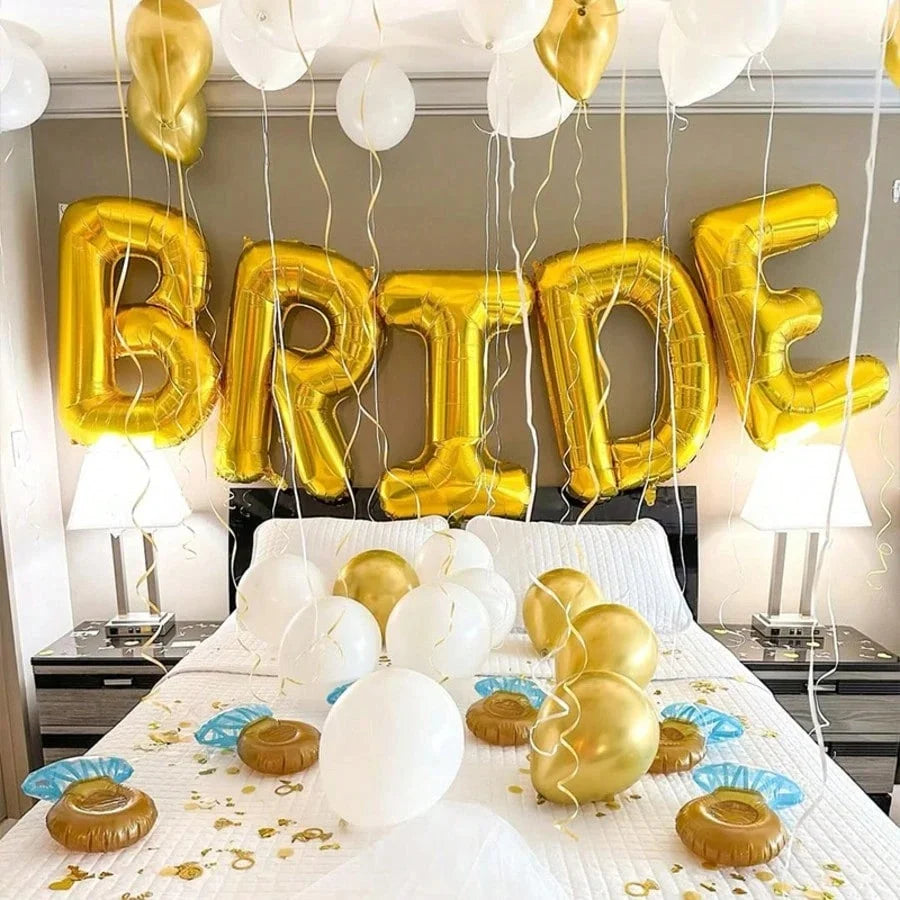 A display of gold and white letter foil balloons spelling BRIDE arranged on a table.