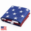 A folded blue and white star American flag with red stripes and brass grommets.