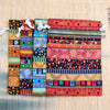 A colorful set of ten vintage cotton drawstring gift pouches featuring intricate geometric and floral patterns.