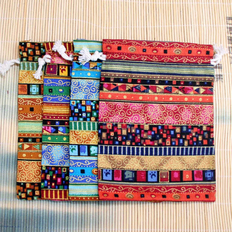 A colorful set of ten vintage cotton drawstring gift pouches featuring intricate geometric and floral patterns.