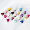 A collection of colorful artificial rose heads in various shades including yellow, pink, purple, and blue.