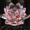 A clear pink crystal lotus flower ornament resting on a dark reflective surface.