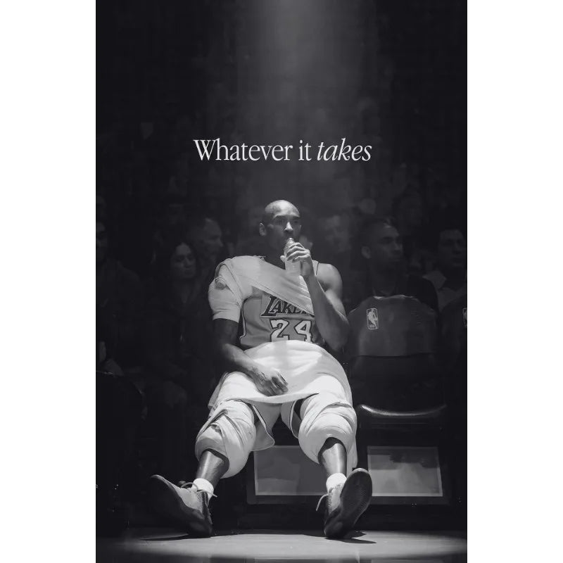 Black and white photo of a basketball player in a white jersey sitting on the court with a spotlight above him.