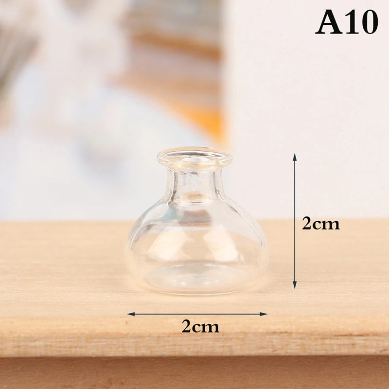 Clear glass miniature vase or bottle with a narrow neck and a wide base, shown on a wooden surface.
