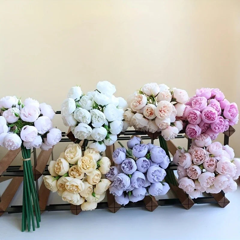A collection of silk peony bouquets in shades of white, pink, and purple arranged on a wooden rack.