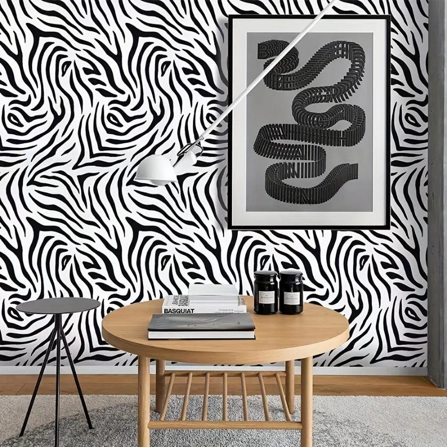 A framed print of a coiled snake in gray on a black and white zebra print wall.