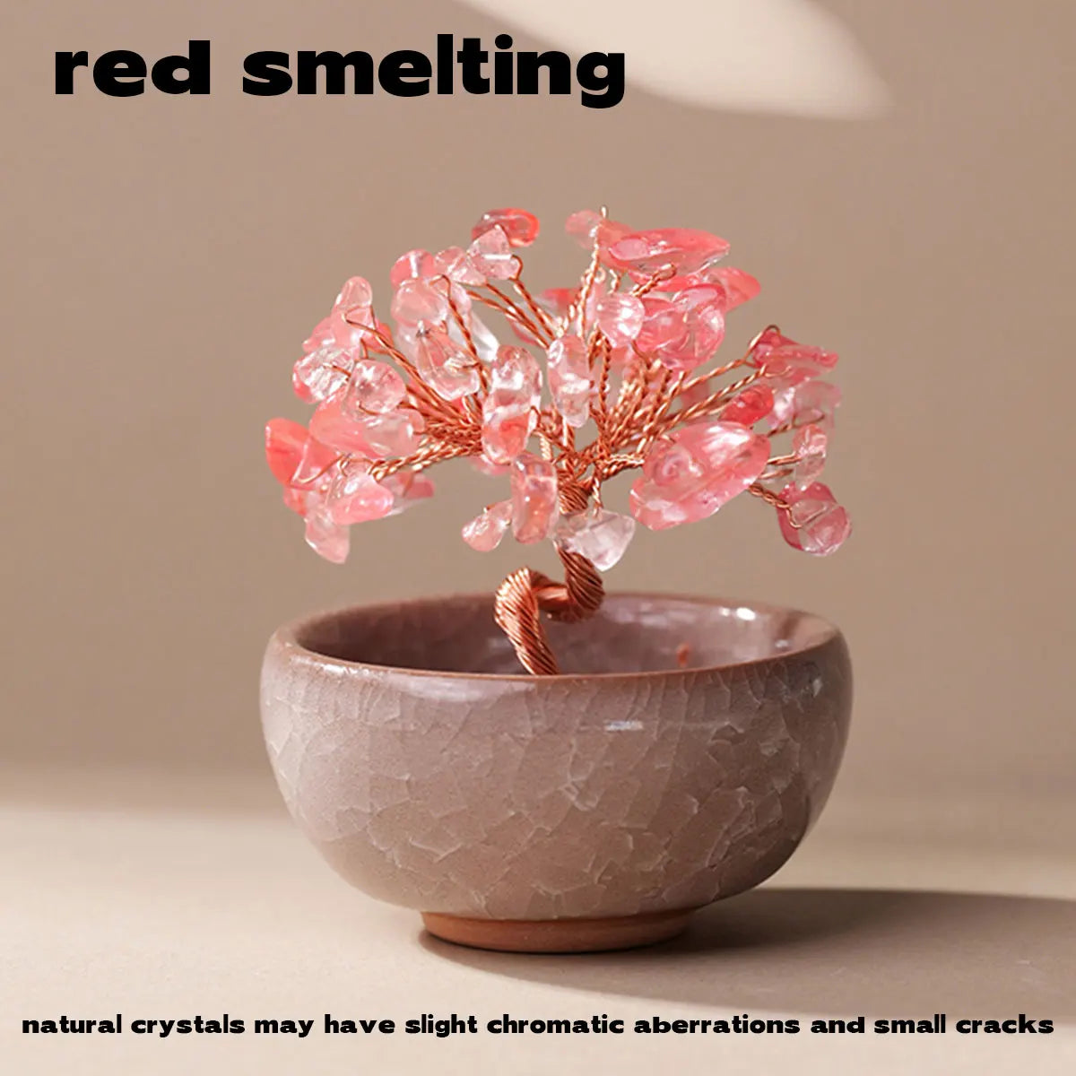 A handcrafted crystal tree with pink quartz crystals mounted on a copper wire base in a beige bowl.