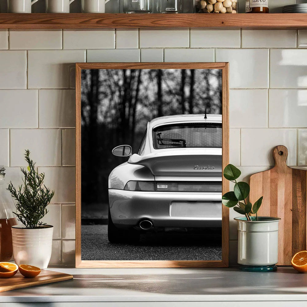 Photo encadrée noir et blanc d'une voiture argentée garée dehors, exposée sur une étagère de cuisine.