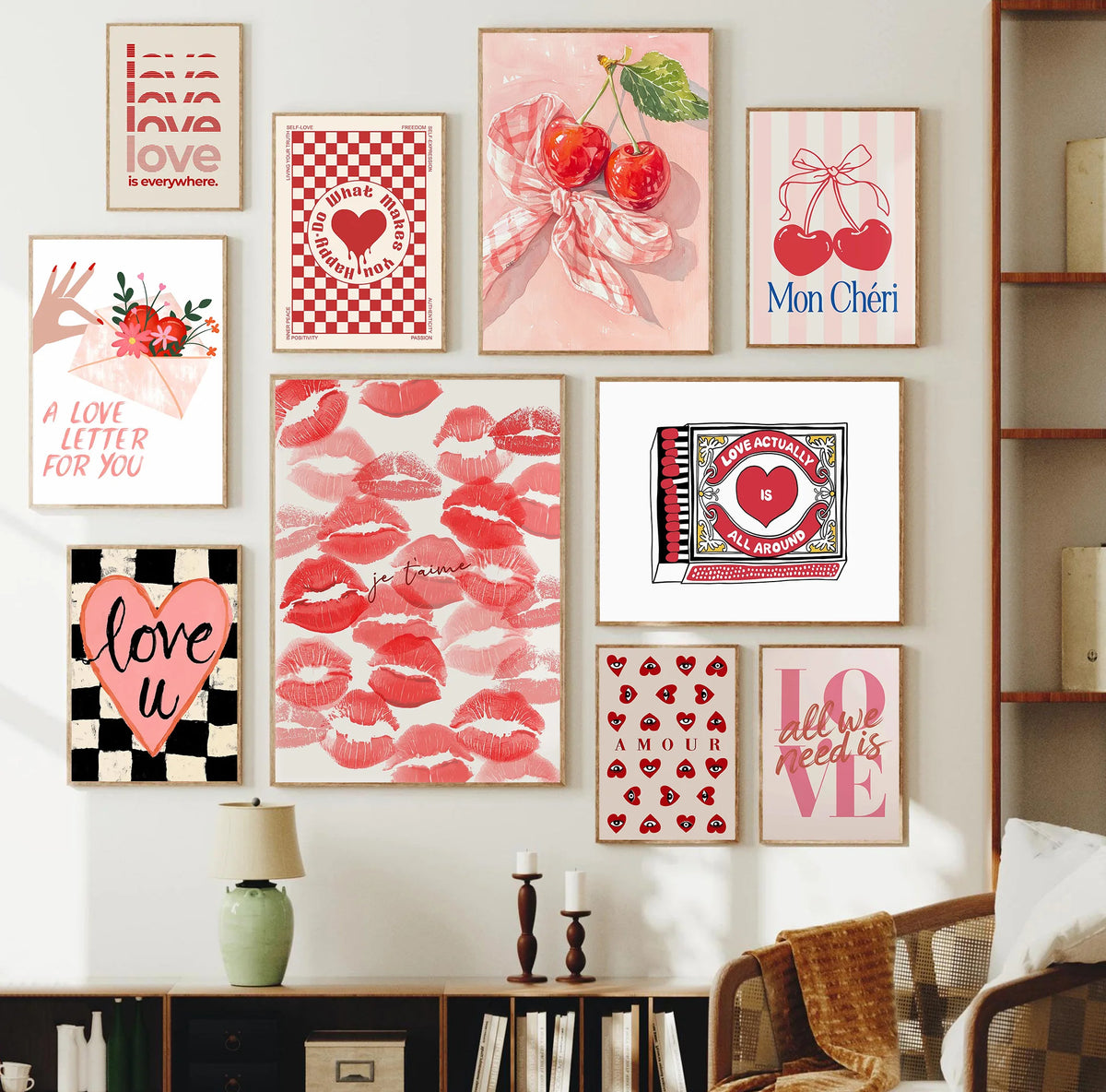 A gallery wall featuring pink and red floral art prints with hearts and bows on a white wall.
