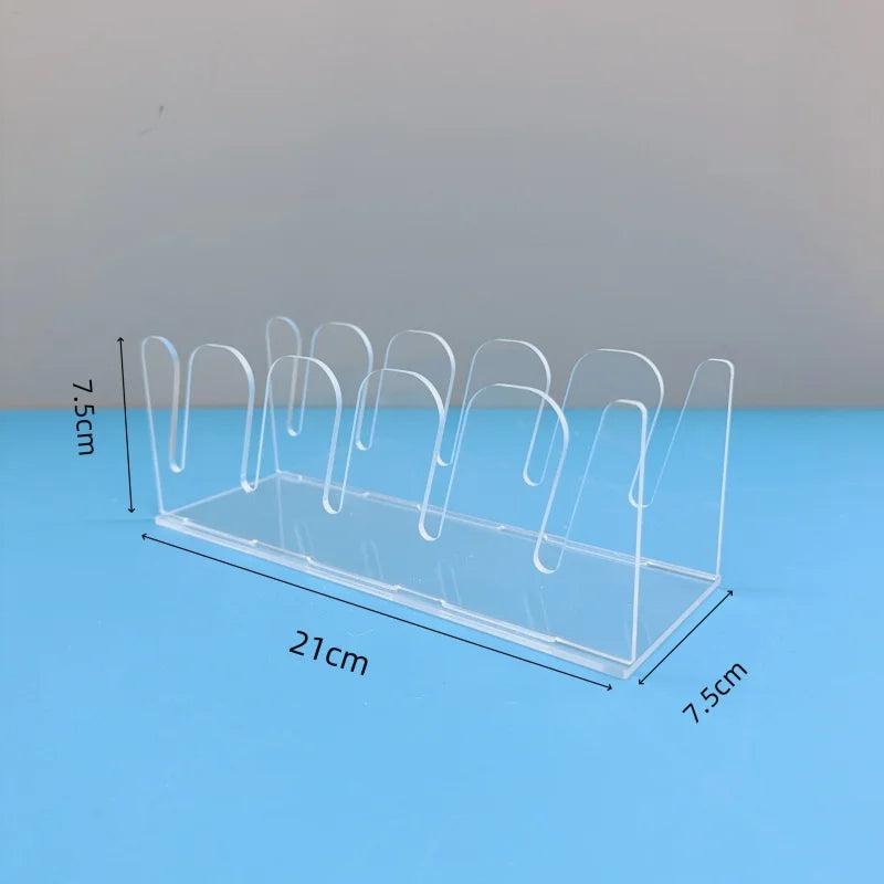 Clear acrylic storage rack with multiple display slots for caps, shown on a blue surface.