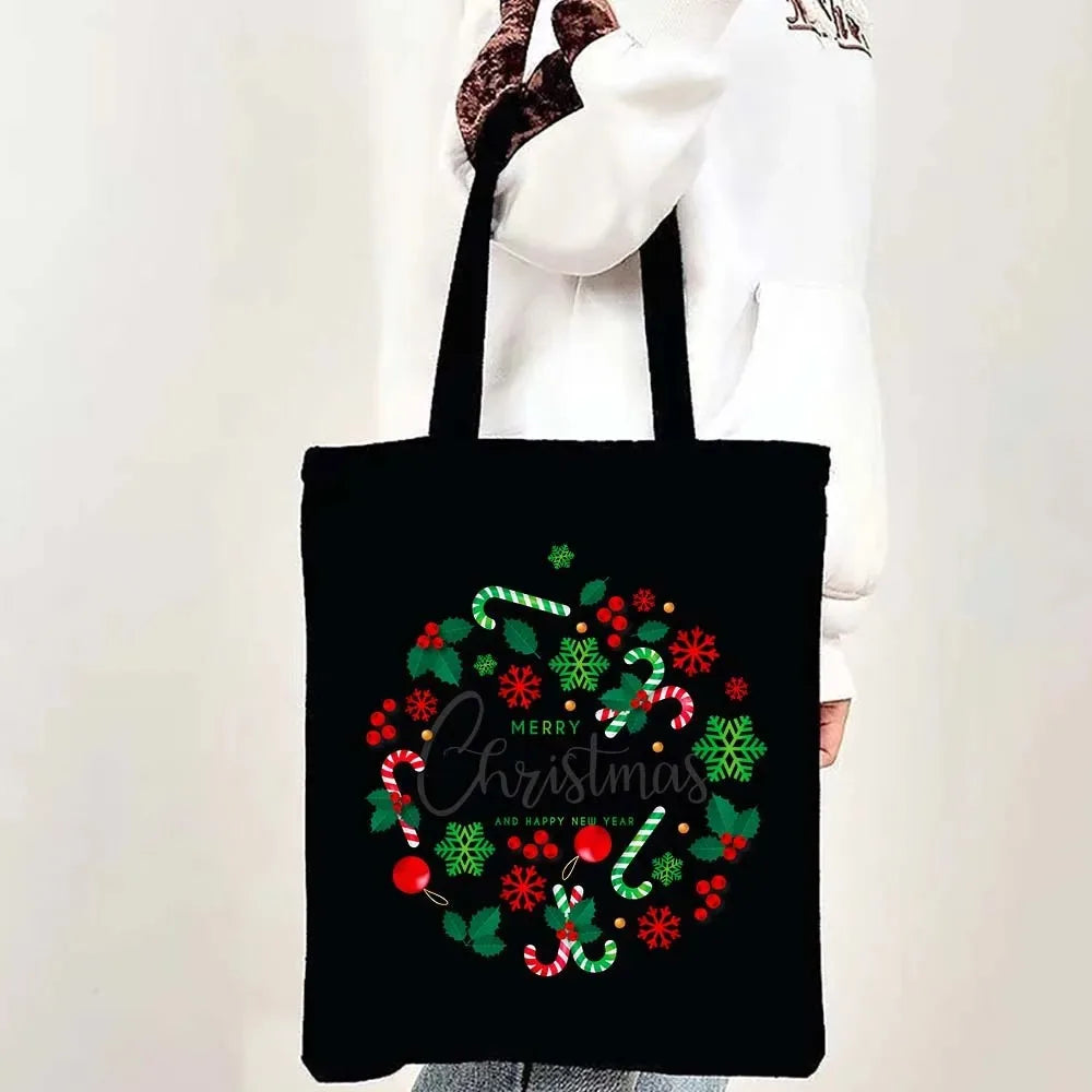 Black tote bag with a festive Christmas design featuring holly, berries, and candy canes.