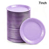 A stack of purple 7-inch disposable paper plates, including one plate lying separately.