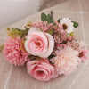 A bouquet of pink and cream roses and hydrangea flowers arranged on a beige linen cloth.