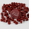 A pile of red wax sealing beads and a circular stamp impression are shown on a white background.