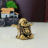 A small brass statue of a laughing Buddha with expressive features, placed on a white surface.