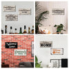 A collection of rustic wooden hanging signs with words like Family, Home, and Welcome displayed on a white wall.