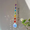 A long necklace featuring a string of colorful crystal prisms and gemstones hanging against a light background.