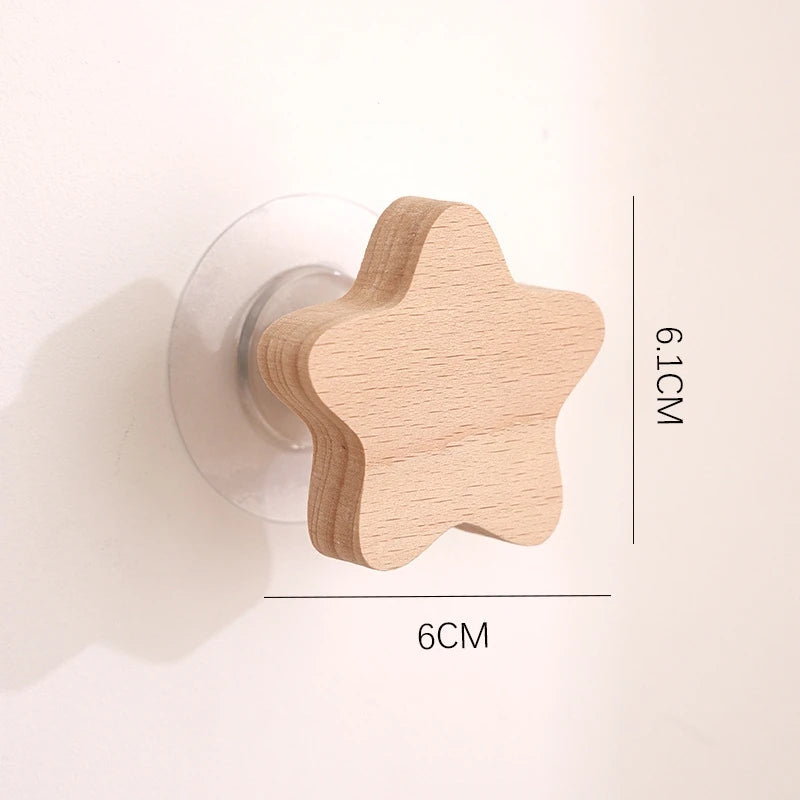 A light wood star-shaped decorative hook with a round mounting plate, shown next to a measurement scale.