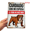 A vintage metal sign featuring text in Spanish and an illustration of a dog, held by a hand.