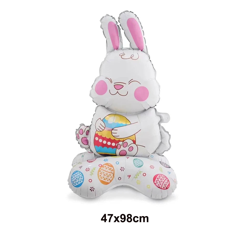 A white cartoon bunny figure made of foil balloons sitting on a surface.